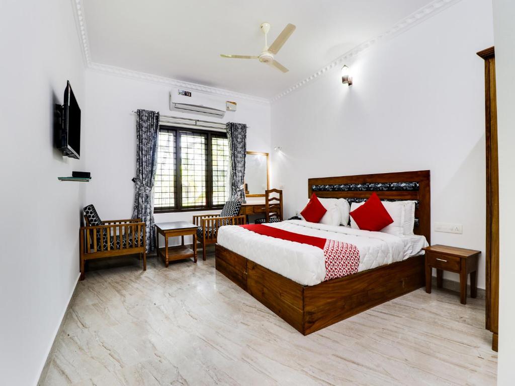 a bedroom with a large bed with red pillows at Star Inn Plus in Kovalam