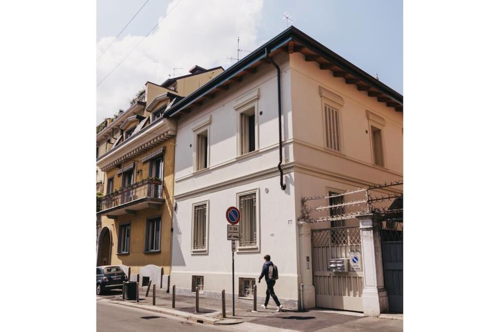 La Casa Bianca في ميلانو: رجل يمشي فوق مبنى ابيض على شارع