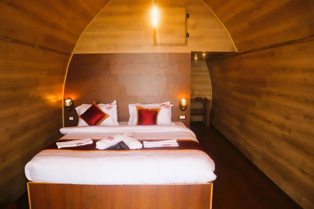 1 dormitorio con 1 cama grande y paredes de madera en Royal Adventures en Kodaikānāl