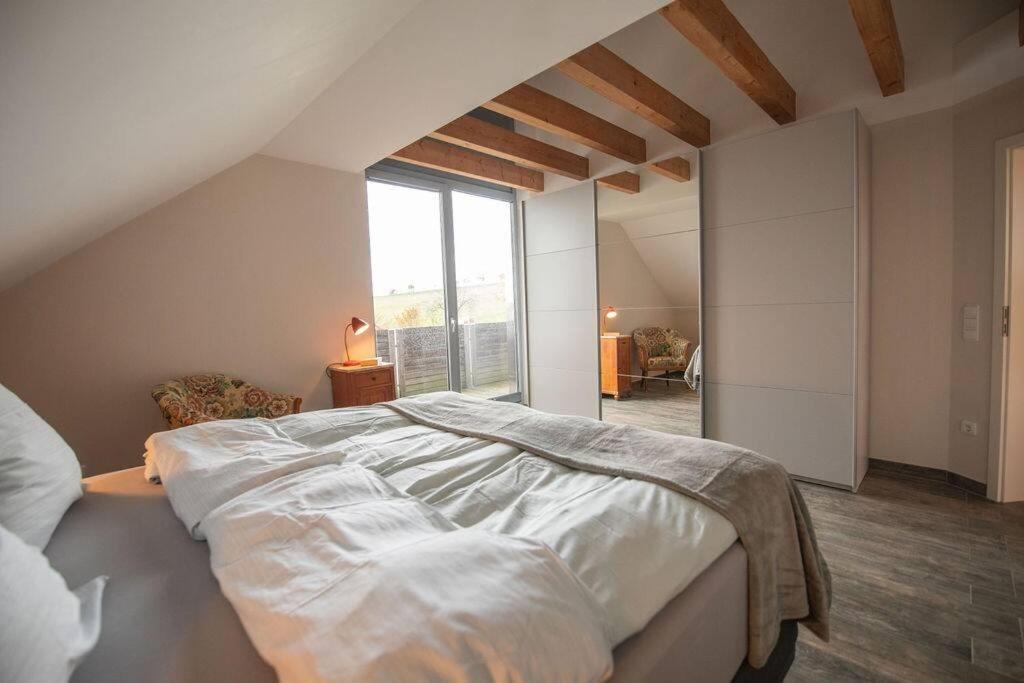 ein Schlafzimmer mit einem großen Bett und einem großen Fenster in der Unterkunft Odenwaldblick in Lützelbach