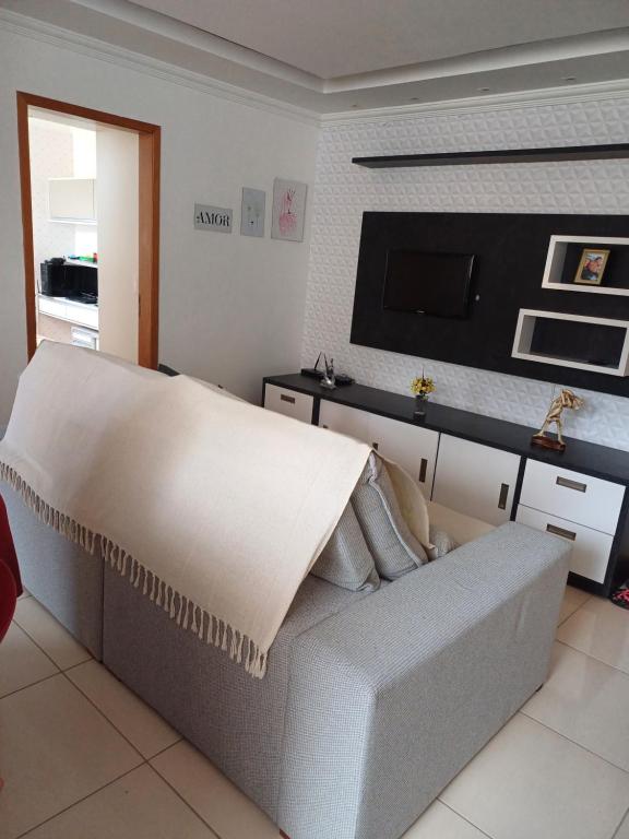 Il comprend un salon doté d'un canapé et d'une télévision à écran plat. dans l'établissement Apartamento Luxo em Vespasiano, à Vespasiano