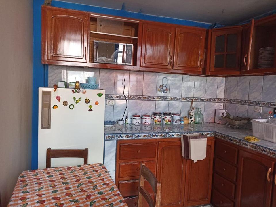 - une cuisine avec des placards en bois et un réfrigérateur blanc dans l'établissement HUANCAYO DPTO ACOJEDOR, à Huancayo