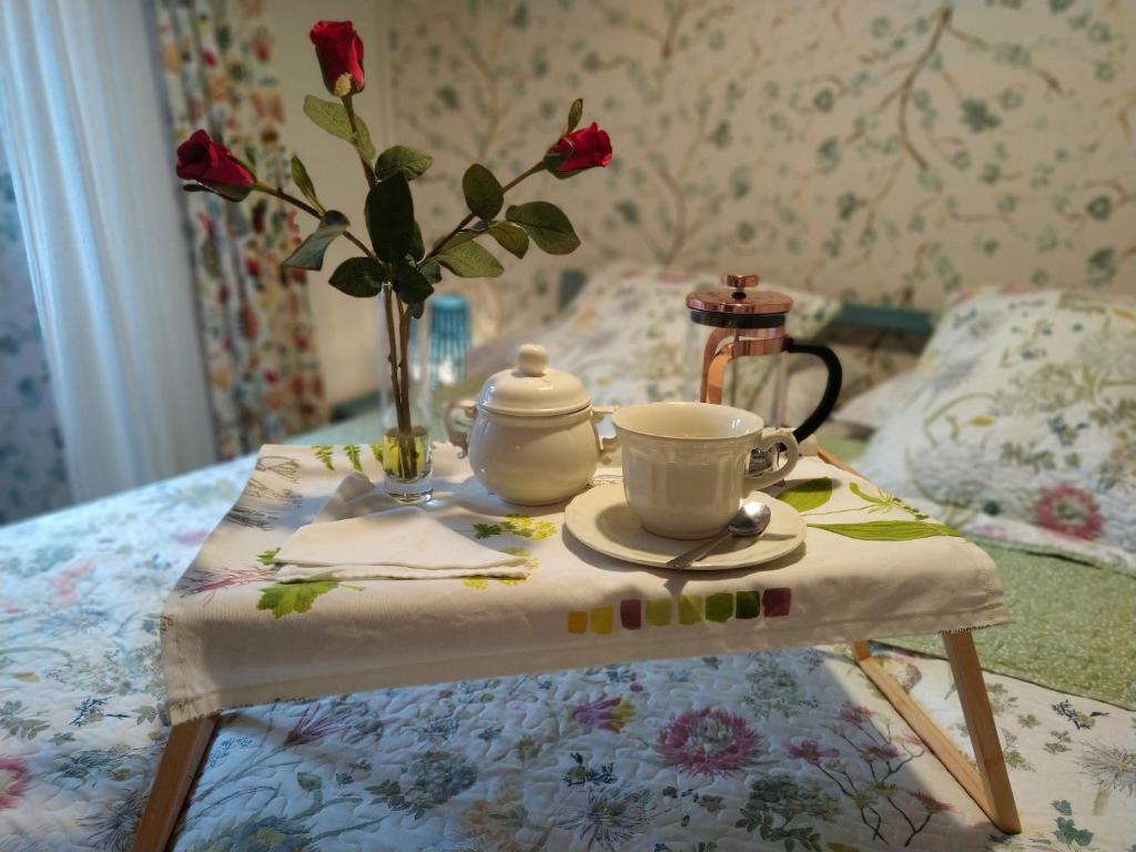 a table with a tea set on it with a vase of roses at La Milana, Orbaneja del Castillo in Orbaneja del Castillo
