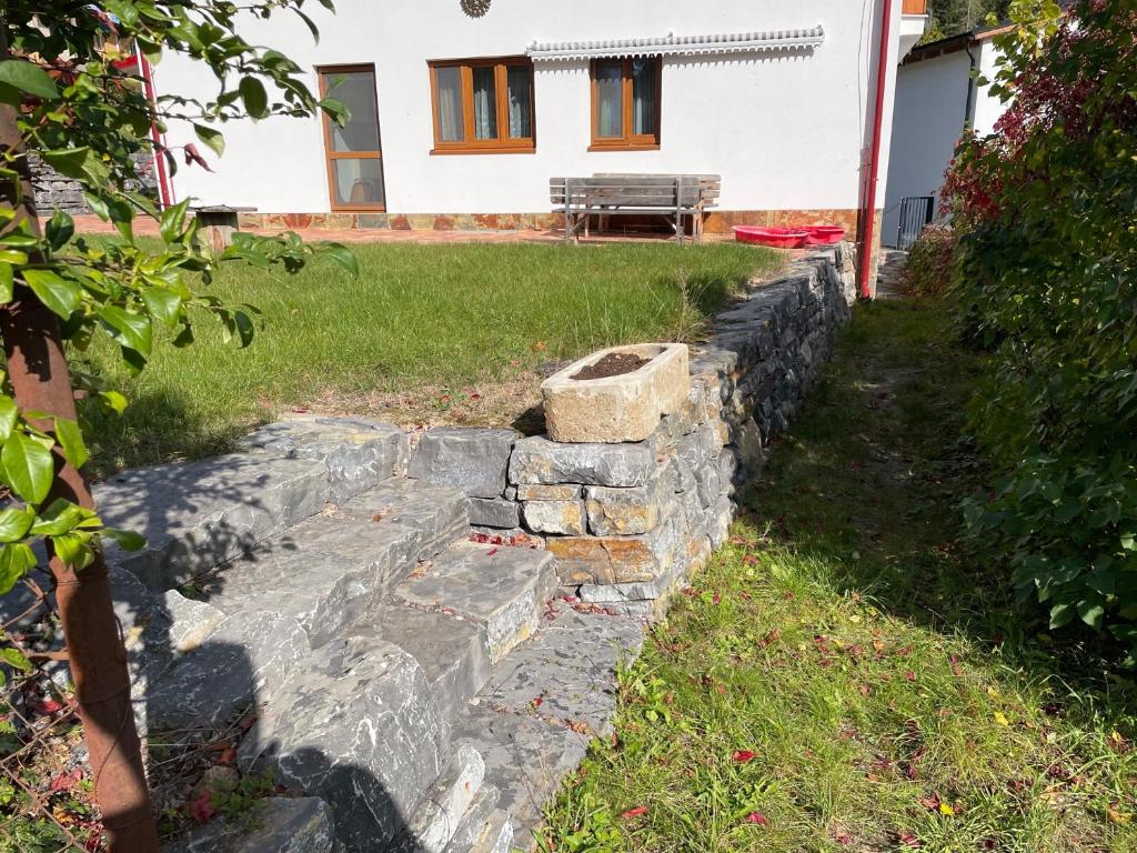 a stone retaining wall in front of a house at Hrdá Ves - Dům U Slunce in Vír