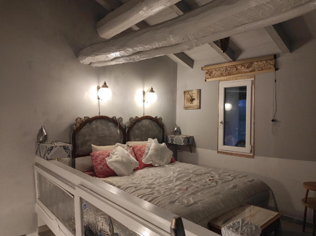 La baia dei lupi في Rezzano: غرفة نوم بها سرير مع مصباحين