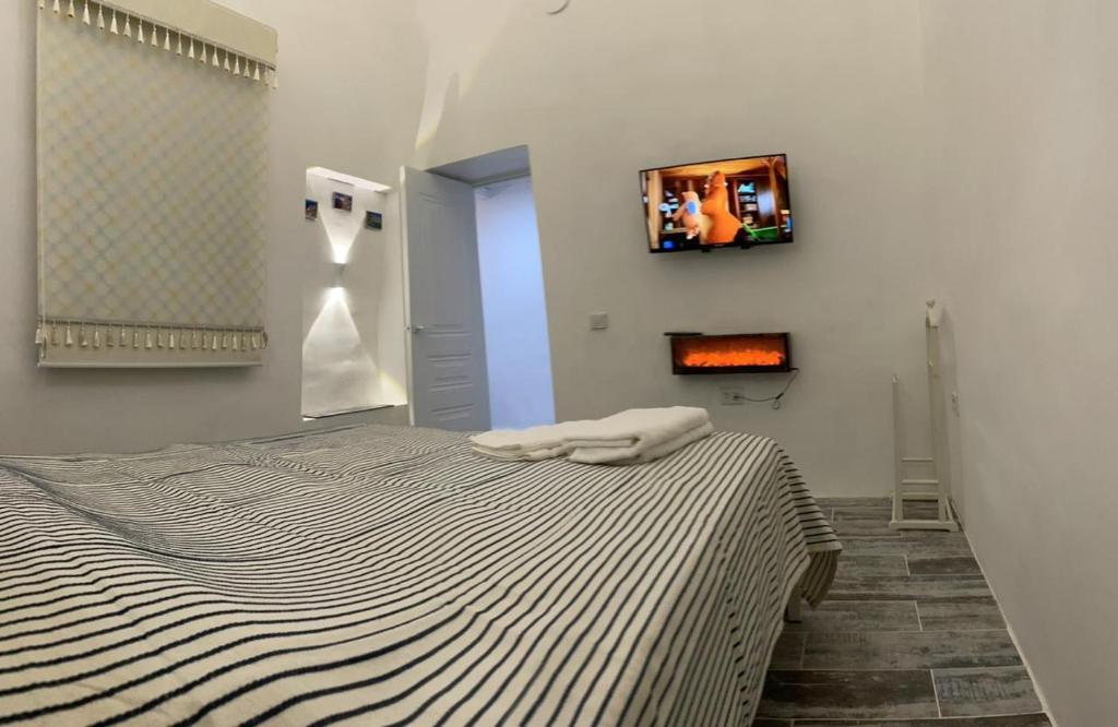 a bedroom with a bed with a tv on the wall at shym_apart in Shymkent