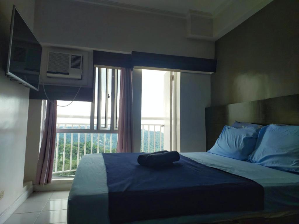 a bedroom with a bed with a large window at 1649 Tagaytay Staycation by Jordy in Tagaytay