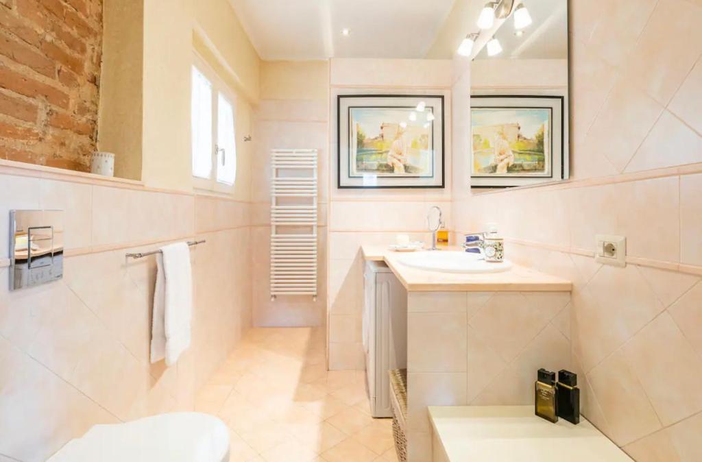 a white bathroom with a sink and a mirror at Lusso e Charme! in Florence