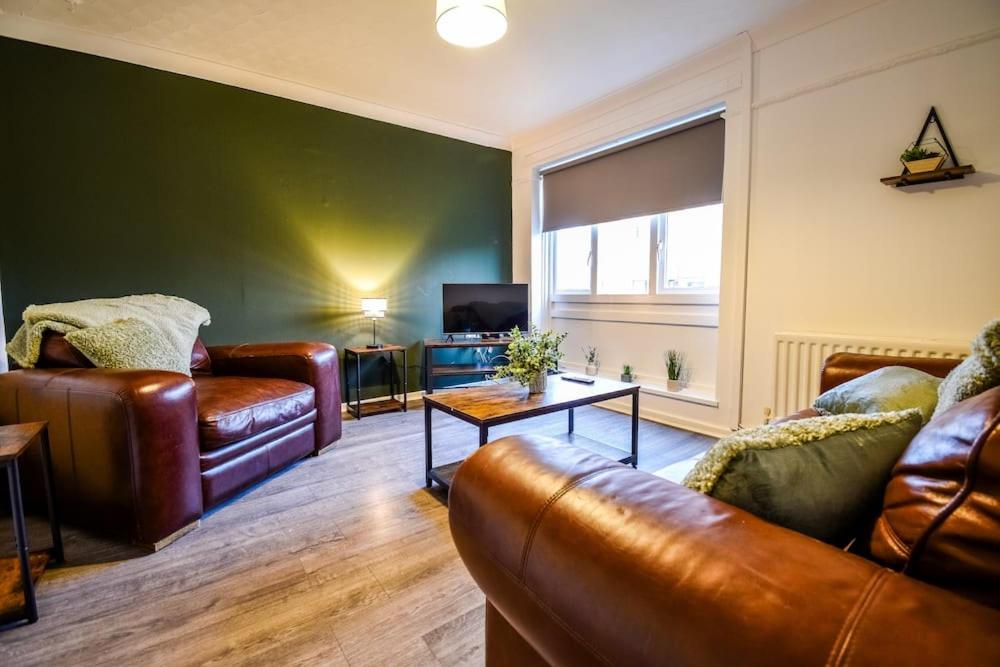 a living room with leather furniture and a window at Woodcock House 3 Bedrooms Workstays UK in Lackenby