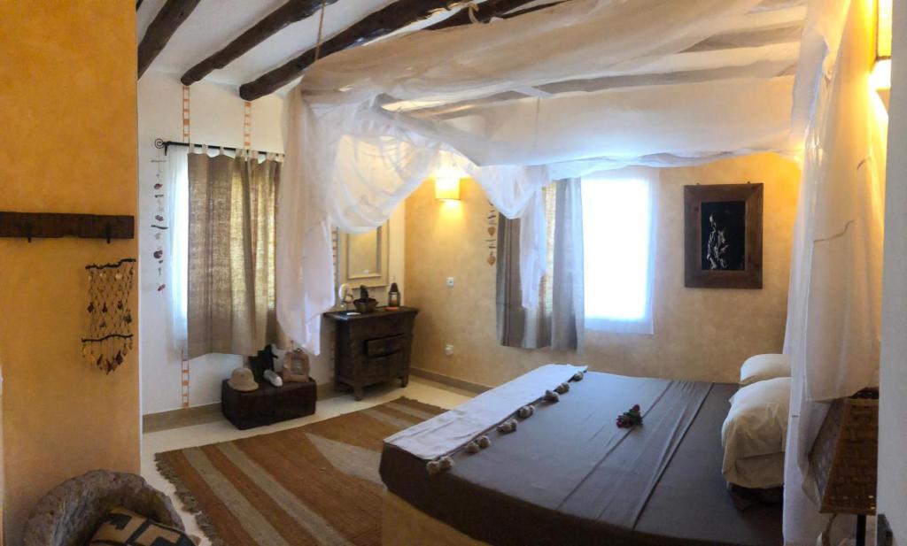 Un dormitorio con una cama grande con dosel. en Piano B suites, en Watamu