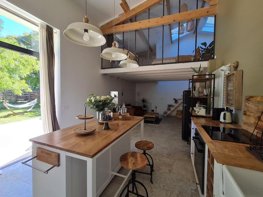 a kitchen with a counter and a large window at Le Mas du Castellas 5* in Le Thor