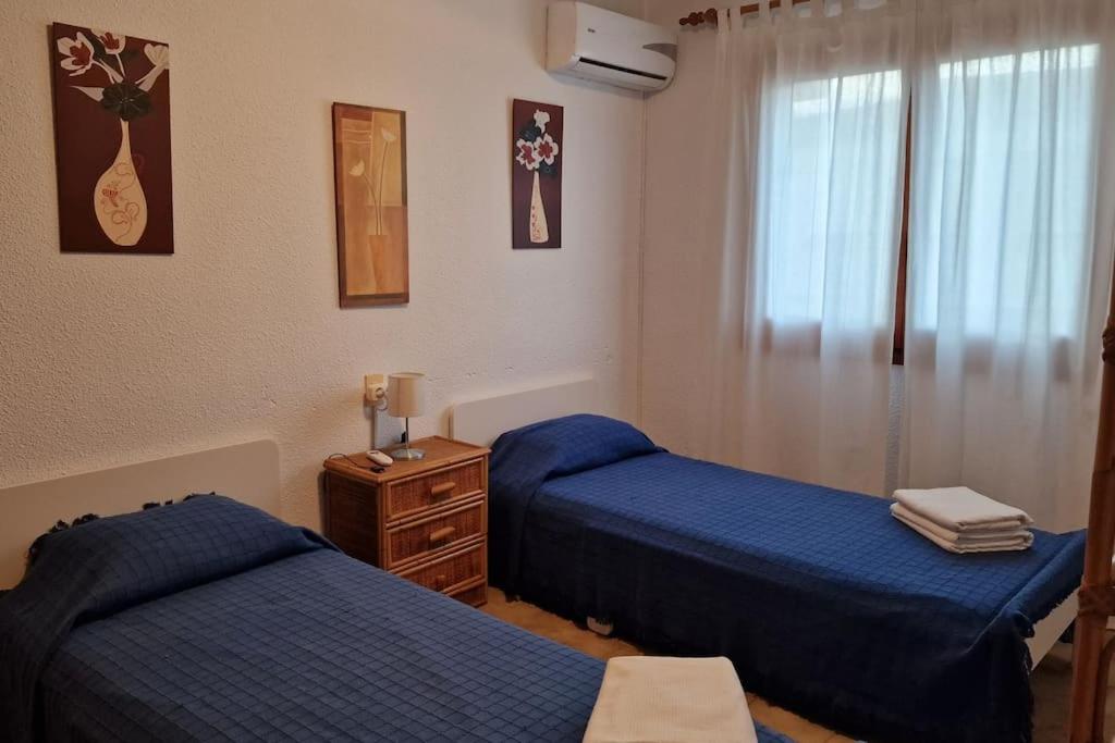1 dormitorio con 2 camas azules y vestidor en Bungalow con jardin y piscina cerca de la playa en Oropesa del Mar