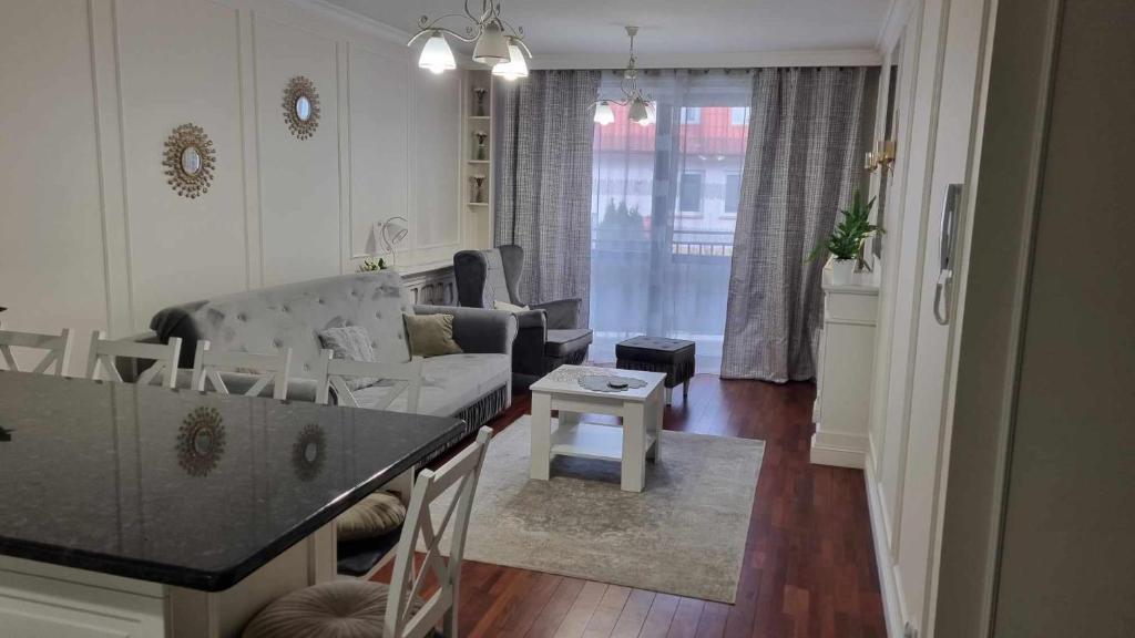a living room with a couch and a table at APARTAMENT w CENTRUM O&K in Augustów