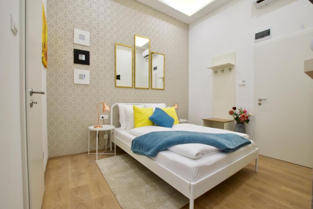 1 dormitorio con 1 cama con almohadas amarillas y azules en St. King 11 Apartments, en Budapest