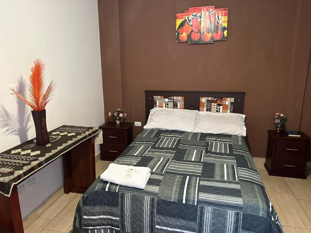 1 dormitorio con 1 cama con mesa en Hostal Aly en Otavalo