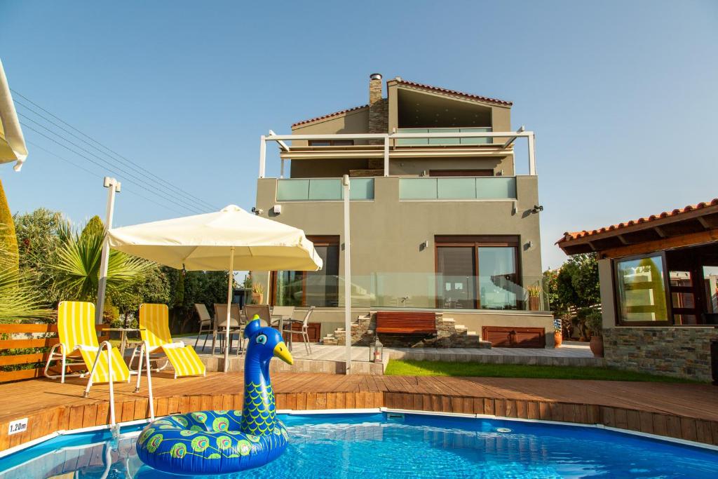 una piscina con un pato de goma azul frente a una casa en A Cozy Eco Villa by the Sea, en Gouves