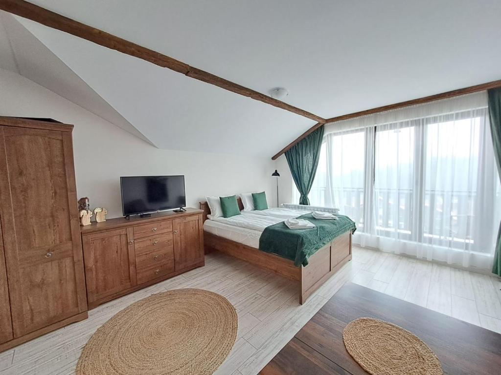 a bedroom with a bed and a large window at Premium Apartment in Borovets Gardens Complex in Borovets