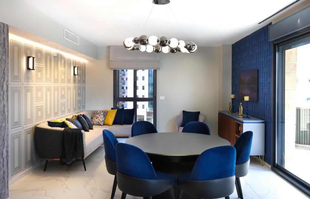 un salon avec un lit, une table et des chaises dans l'établissement 4Corners Retreat- Center of Town, Jerusalem, à Jérusalem