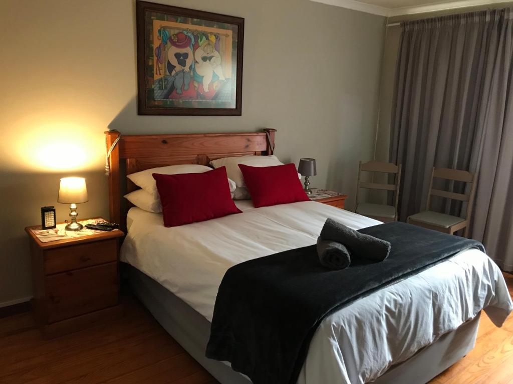 1 dormitorio con 1 cama grande con almohadas rojas en Upstairs at the Miles’, en George