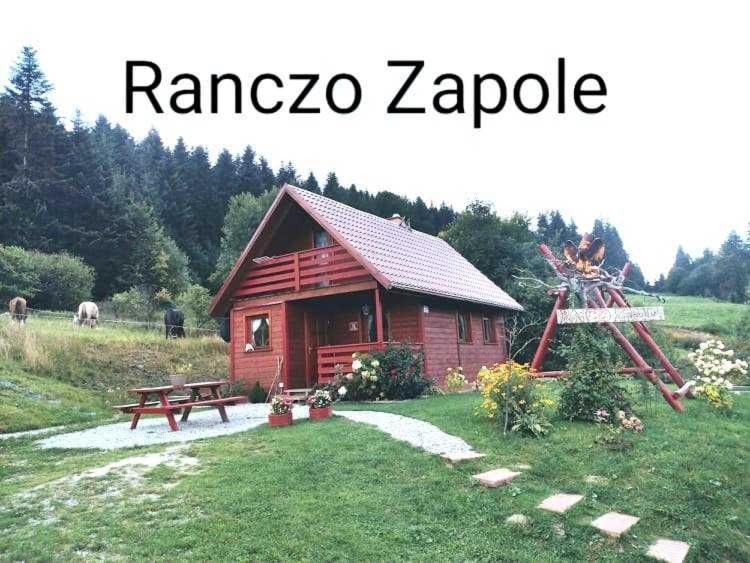 mały domek z bali ze stołem piknikowym i ławką w obiekcie Ranczo Zapole w mieście Zasadne