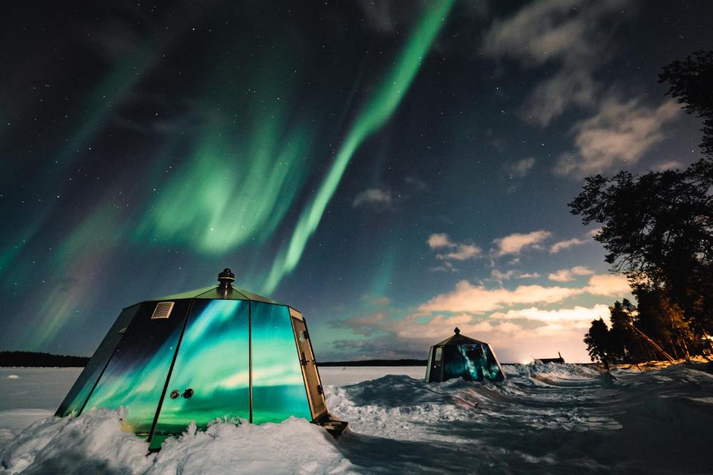 two tents in the snow under the northern lights at Aurora Nest – Eco Glass Igloo in Rovaniemi