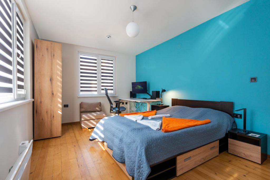 1 dormitorio azul con 1 cama con pared azul en DevIn Coworking & Coliving en Devin