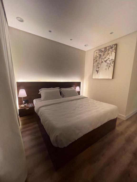 een slaapkamer met een groot bed met witte lakens bij شقة فاخرة بالقرب من البوليفارد Apartment next to boulevard city- world &arean kingdom in Riyad