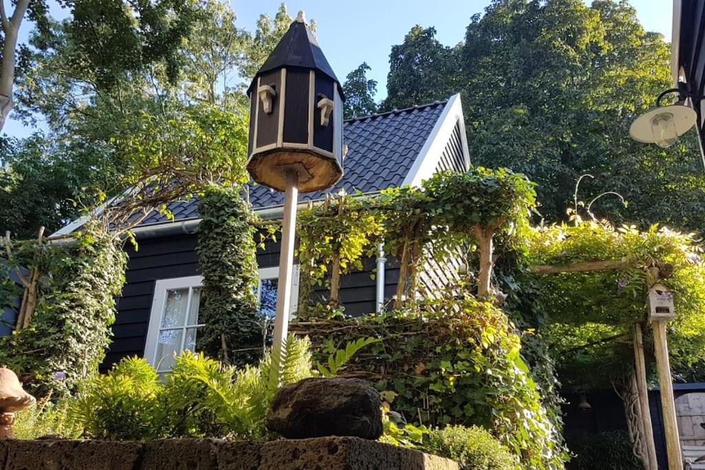 una casa con un alimentador de aves delante de ella en Tiny House Tholen, en Tholen