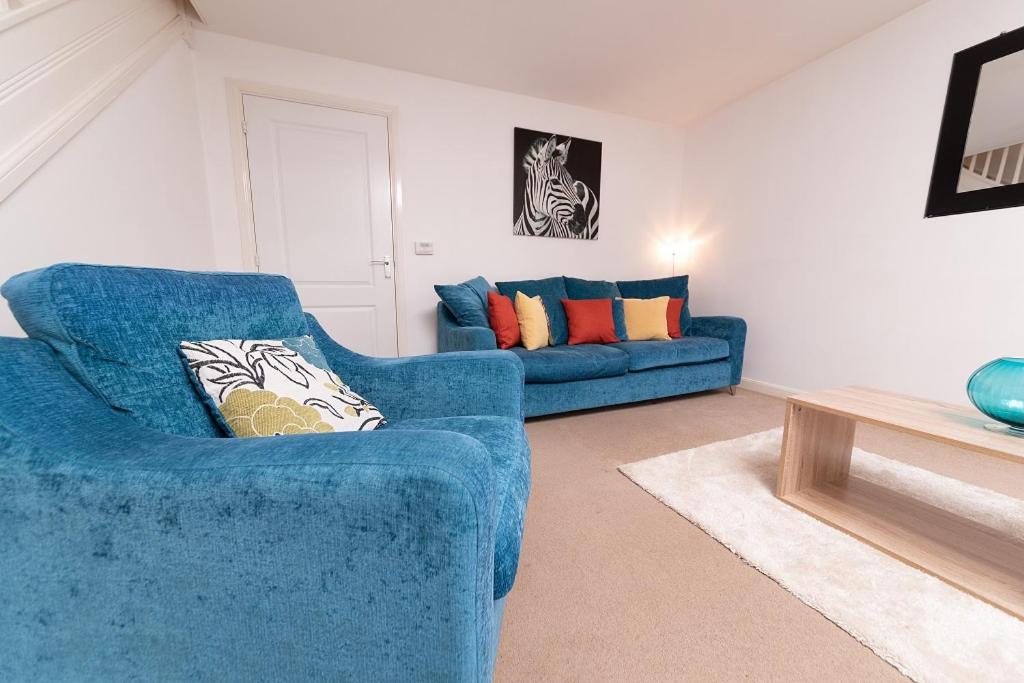 a living room with a blue couch and a table at Pacific House in Thornaby on Tees