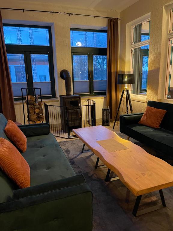 Una sala de estar con dos sofás y una mesa de café. en Ferienwohnung mit Kamin und traumhafter Dachterrasse mit Weitblick in die Natur, en Neu Gaarz