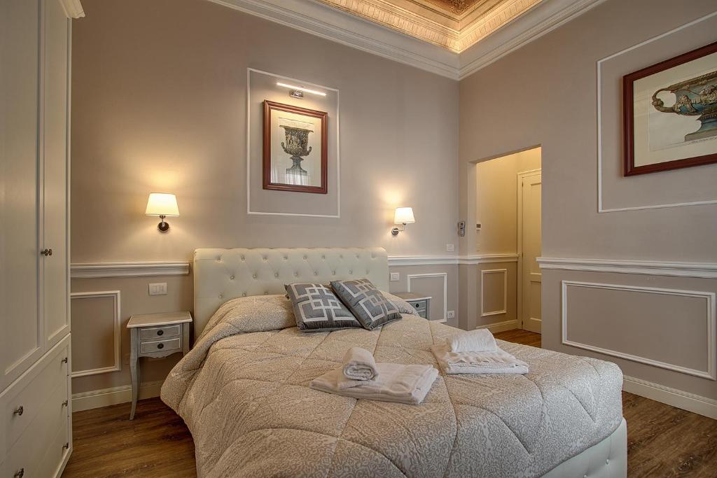 1 dormitorio con 1 cama con 2 toallas en Art Apartment Luxury Tintori Suite, en Florencia