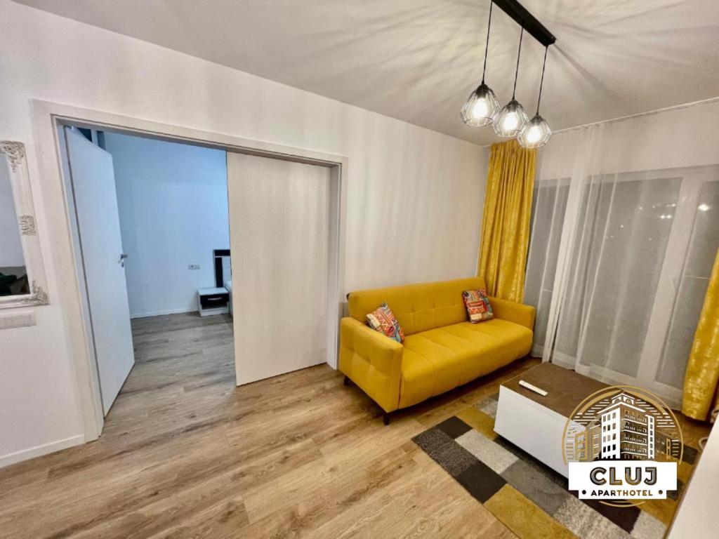 uma sala de estar com um sofá amarelo e uma porta de correr em Cluj ApartHotel - VIVA CITY - em Cluj-Napoca
