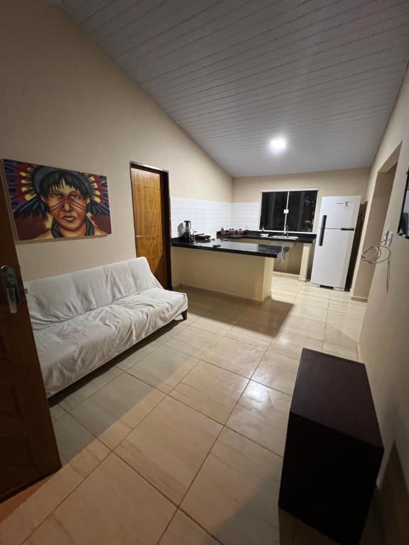 ein Wohnzimmer mit einem Bett und eine Küche in der Unterkunft Casa do alto pipa in Pipa