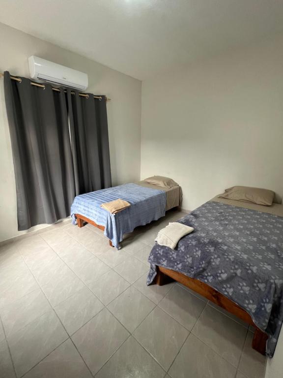 2 camas en una habitación con ventana en La casa del profe, en Tampico