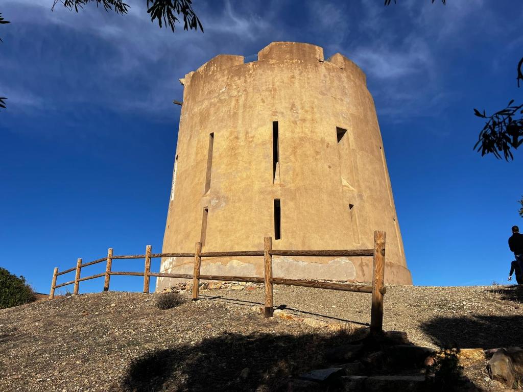 una torre en la cima de una colina con una valla en Casa vacanze Sardegna B, en Tertenìa