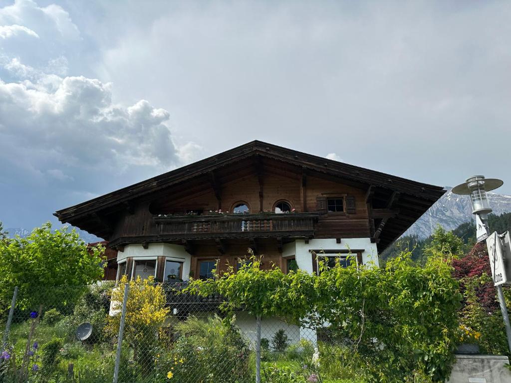 une grande maison en bois au sommet d'une colline dans l'établissement Ferienwohnung Volgger, à Mils bei Hall