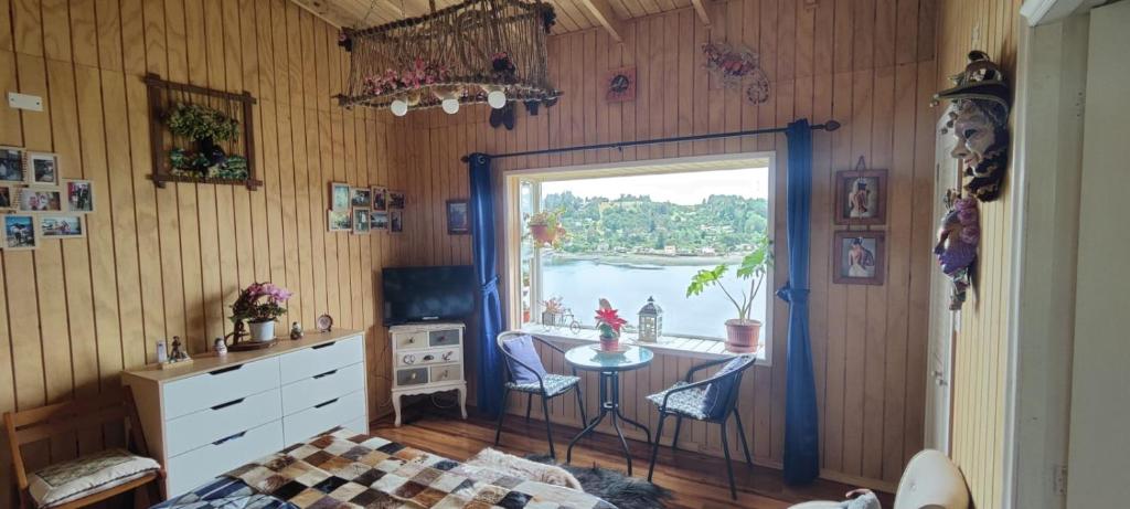 Dormitorio con ventana, cama y mesa en Habitación con vista al mar en Puerto Montt