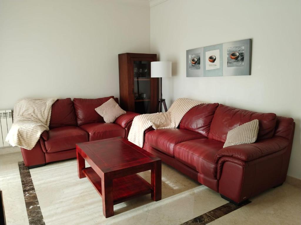 a living room with a red couch and a table at Apartamento 3 dormitorios Roda Golf in Murcia