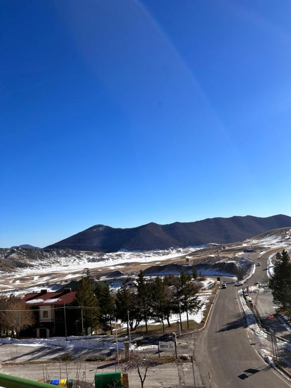 a view of a road with snow and mountains at Brown bear home in Roccaraso