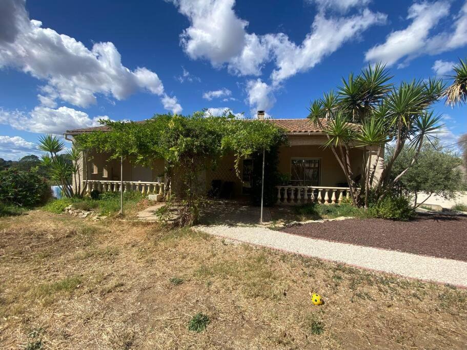 une maison avec une clôture devant une cour dans l'établissement Maison près des vignes, à Castelnau-de-Guers