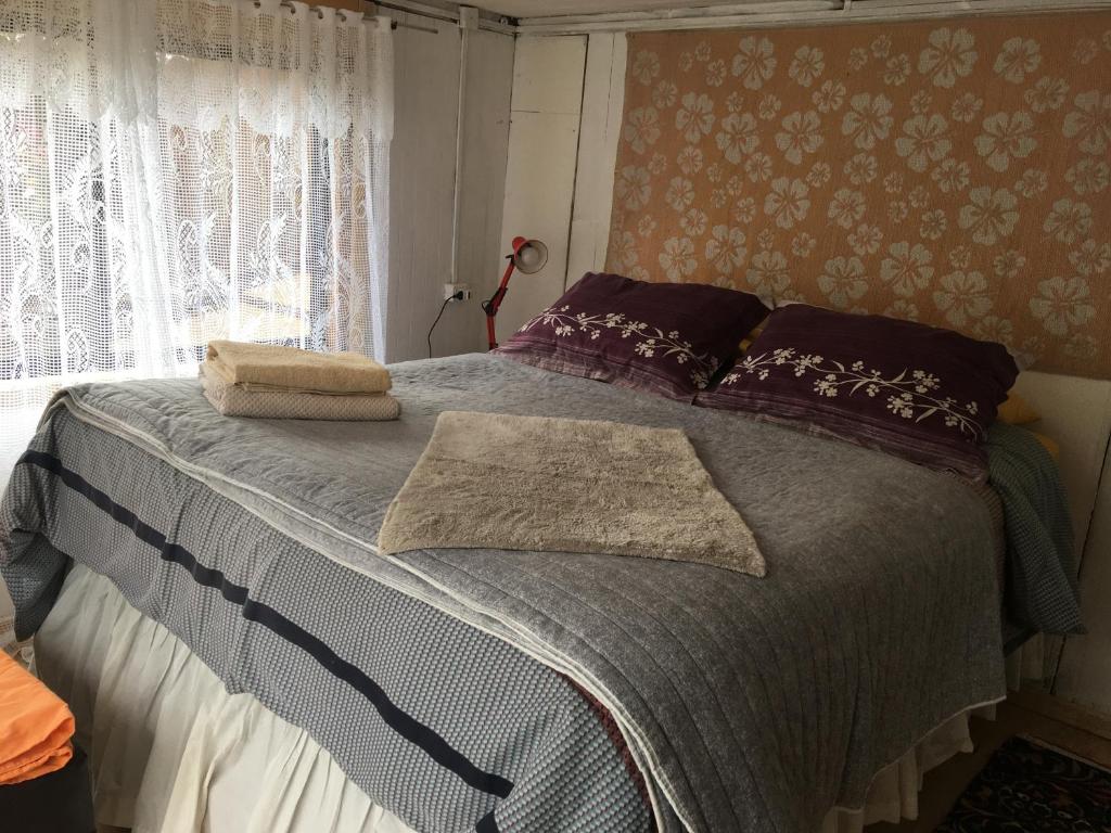 een slaapkamer met een bed met paarse kussens en een raam bij Fran&EmmaIII in Temuco