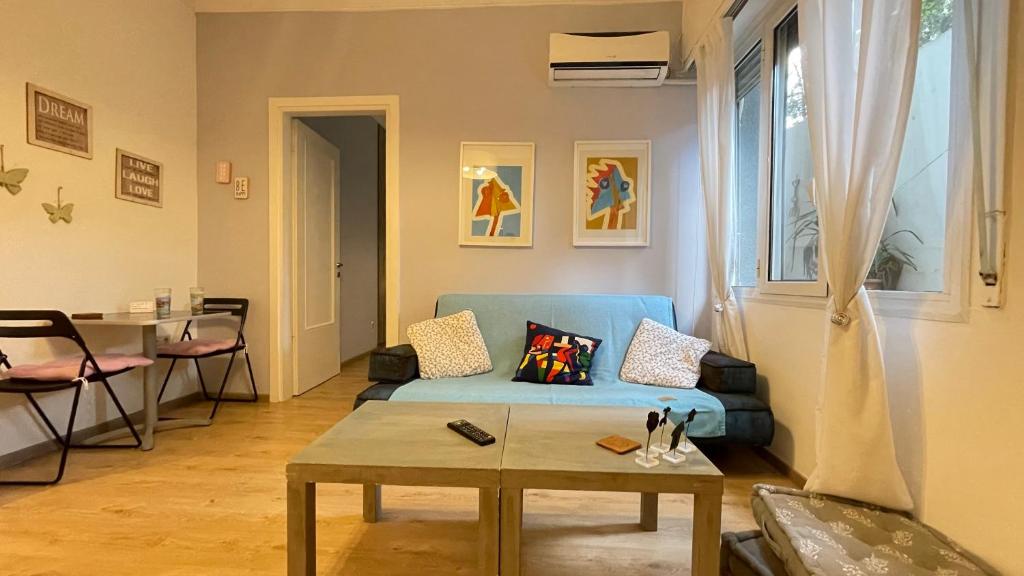 ein Wohnzimmer mit einem blauen Sofa und einem Tisch in der Unterkunft Cozy apartment ideally located city center and Megaron Moussikis metro station in Athen