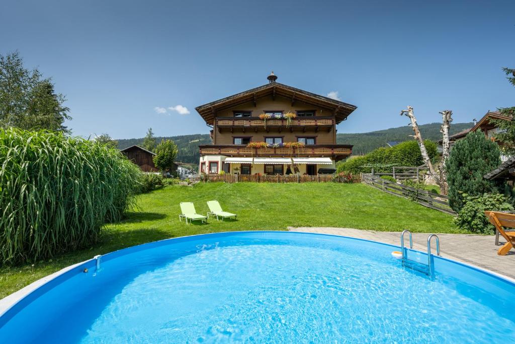 una casa con piscina frente a una casa en Landhaus Aubauerngut, en Radstadt