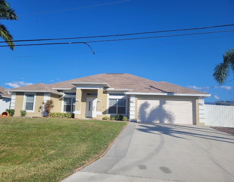 a house on a street with a driveway at Abode Villas in Cape Coral