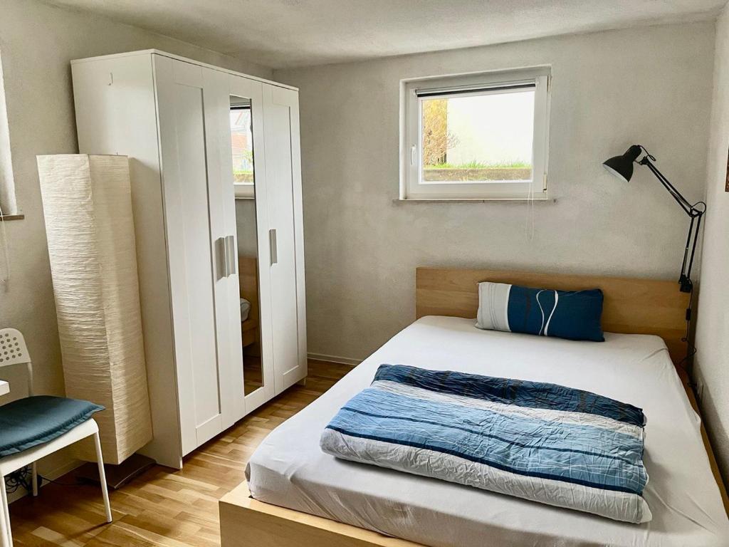 Habitación pequeña con cama y ventana en Modernes Studio mit separater Küche, en Reutlingen