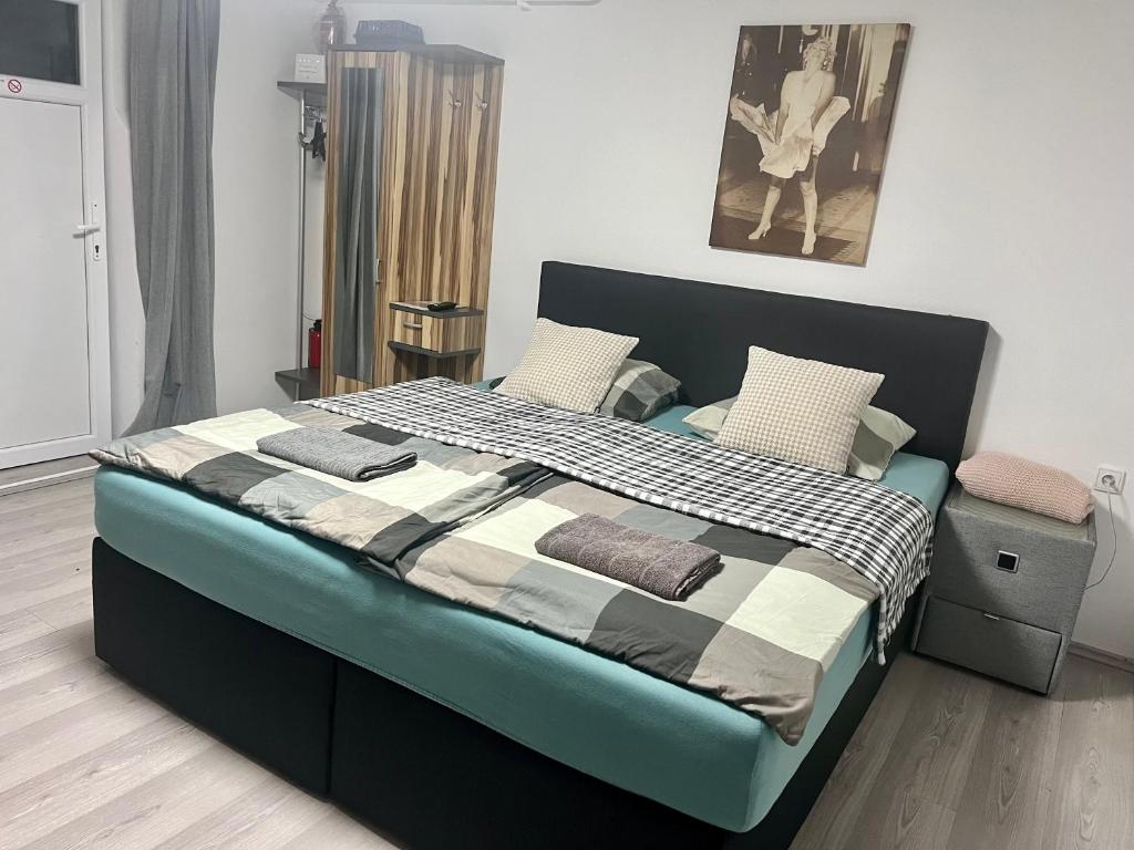 a bedroom with a large bed with a black and white comforter at Apartmánek Patricie room with kitchenette suitable for 2 adults and 2 children in Mikulov