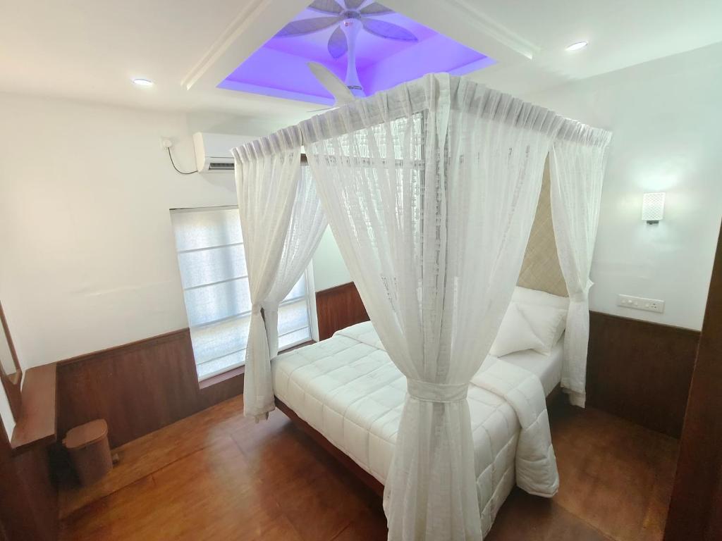 a bedroom with a canopy bed with a purple ceiling at SR Houseboats Kumarakom in Kumarakom