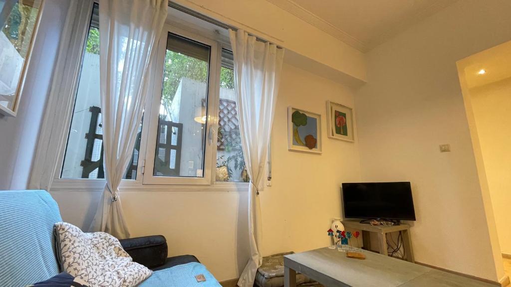 A television and/or entertainment centre at Cozy apartment ideally located city center and Megaron Moussikis metro station