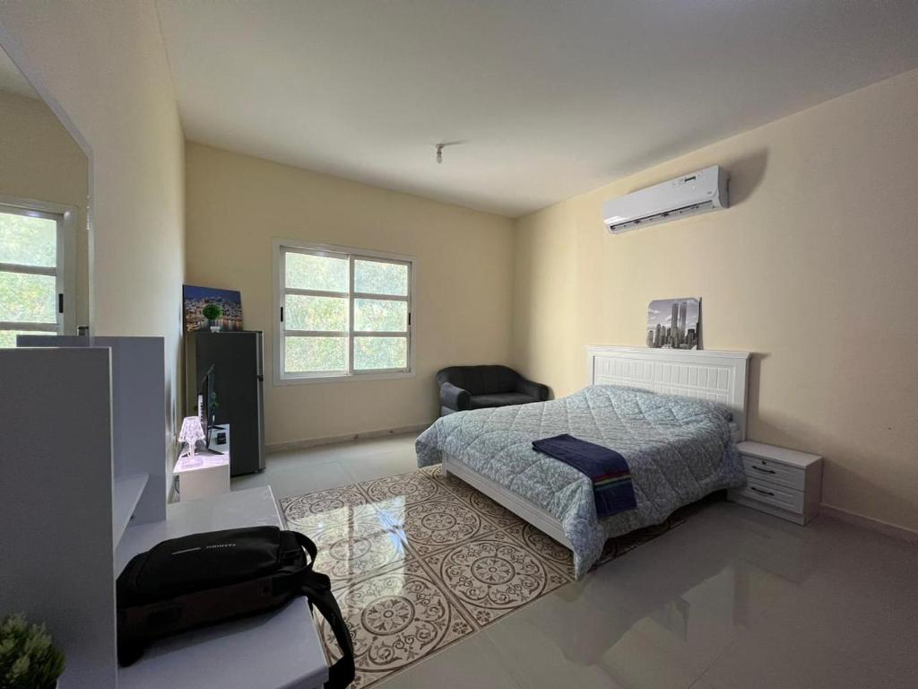 a bedroom with a bed and a chair in it at Furnished Studio Apartment in Abu Dhabi