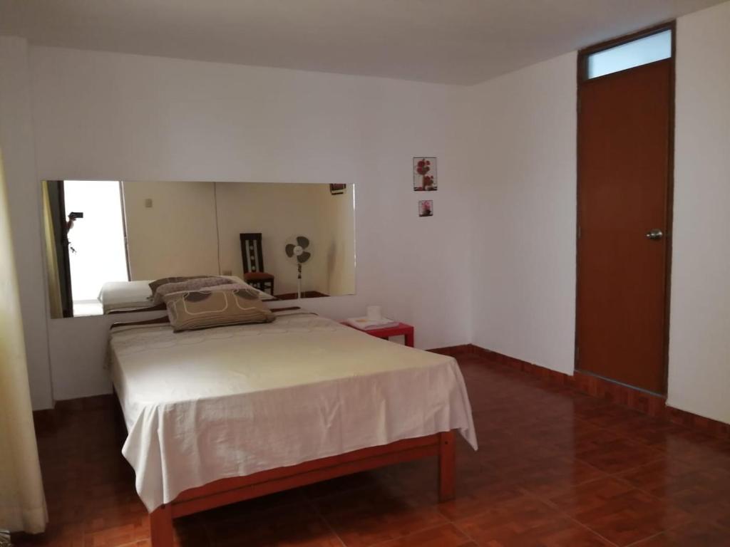 1 dormitorio con cama y espejo grande en Hotel Huanchaco, en Trujillo